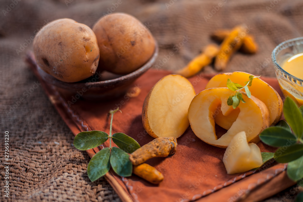 Potato face mask consisting of grated potato and some turmeric powder or haldi in a glass bowl on jute bags surface to brighten the skin, kills bacteria and germs. Potato face mask consisting of grated potato and some turmeric powder or haldi in a glass bowl on jute bags surface to brighten the skin, kills bacteria and germs.