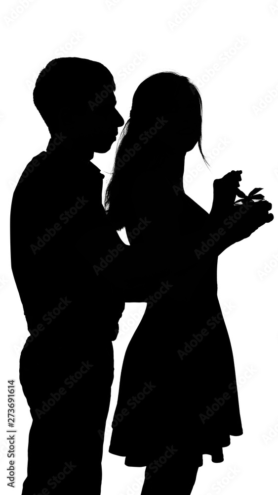 man making unexpected surprise for woman, boy walked behind and covered girl's eyes with his hand to give rose and gift box on a white isolated background, concept of dating, romance and love