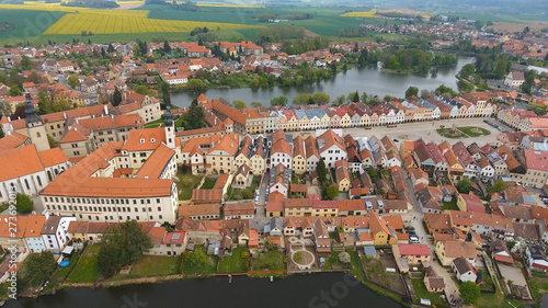 Aerial view of buildings with red tile roofs on medieval square and Old Castle Telc, Czech Republic
