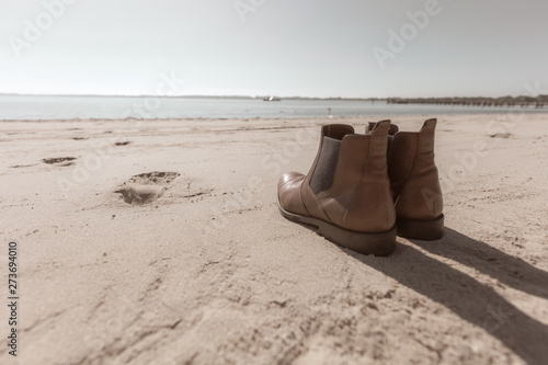 a pair of shoes standing on the beach