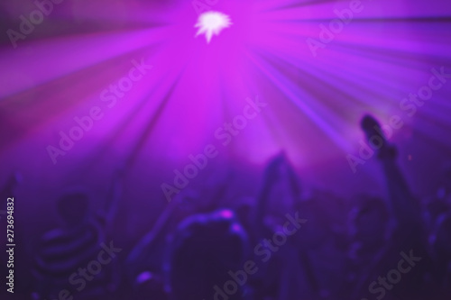 Lighting in club party,blur silhouettes of happy people crowd having fun and dancing in club party. © kowit1982