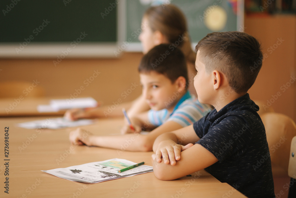 Schoolboy rise hand in classroom. Elementary school. Education Schoolboy rise hand in classroom. Elementary school. Education