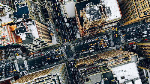 Aerial view of New York downtown building roofs. Bird's eye view from helicopter of cityscape metropolis infrastructure, traffic cars, yellow cabs moving on city streets and crossing district avenues
