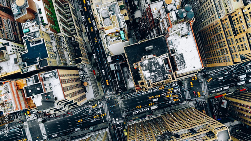 Aerial view of New York downtown building roofs. Bird's eye view from helicopter of cityscape metropolis infrastructure, traffic cars, yellow cabs moving on city streets and crossing district avenues