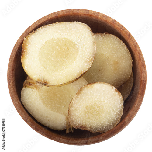 heap of slices of fresh galangal root in wooden cup  isolated on white background. top view