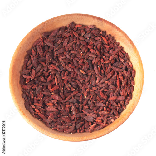 heap of dried goji berries in wooden plate isolated on white background. top view