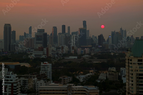 Panoramic view of the sun setting over skyscrapers in Bangkok downtown  Thailand