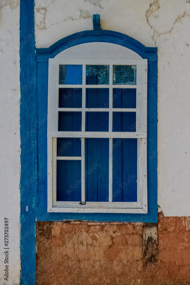 Colonial withe window with blue frame, made of wood of the Pirenopolis