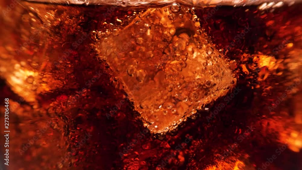 Macro shot of glass with cola and ice cubes. A lot of bubbles going up. 4k. Macro shot of glass with cola and ice cubes. A lot of bubbles going up. 4k.