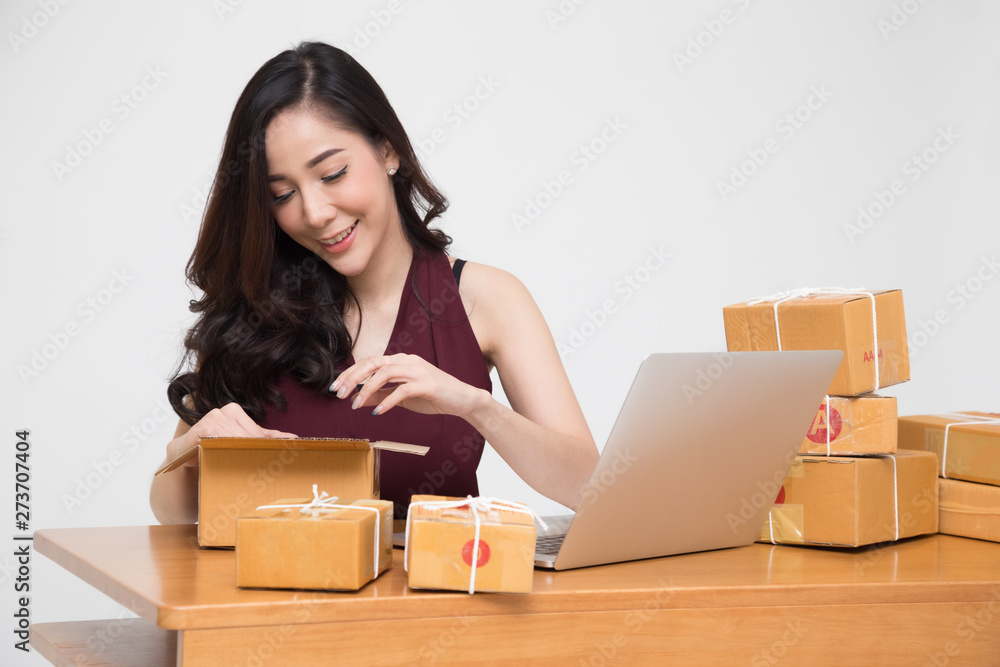 Asian women packing parcel on the table and white background, Female receive cardboard box from buying online orders, Shipping delivery and shopping by internet concept Asian women packing parcel on the table and white background, Female receive cardboard box from buying online orders, Shipping delivery and shopping by internet concept