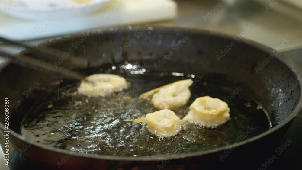 Chef frying squid rings in a frying pan. Tasty snack Chef frying squid rings in a frying pan. Tasty snack