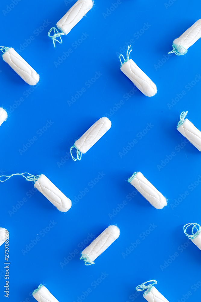 Menstrual period concept with tampons on blue background top view pattern Menstrual period concept with tampons on blue background top view pattern