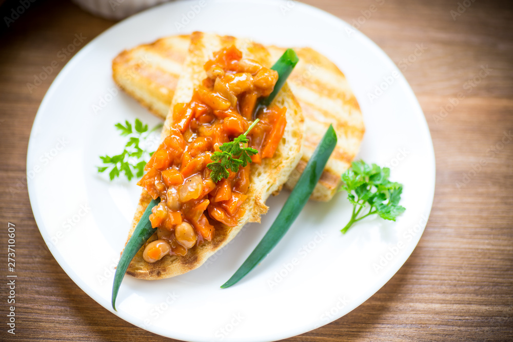 fried bread toasts with stewed beans and vegetables in a plate fried bread toasts with stewed beans and vegetables in a plate