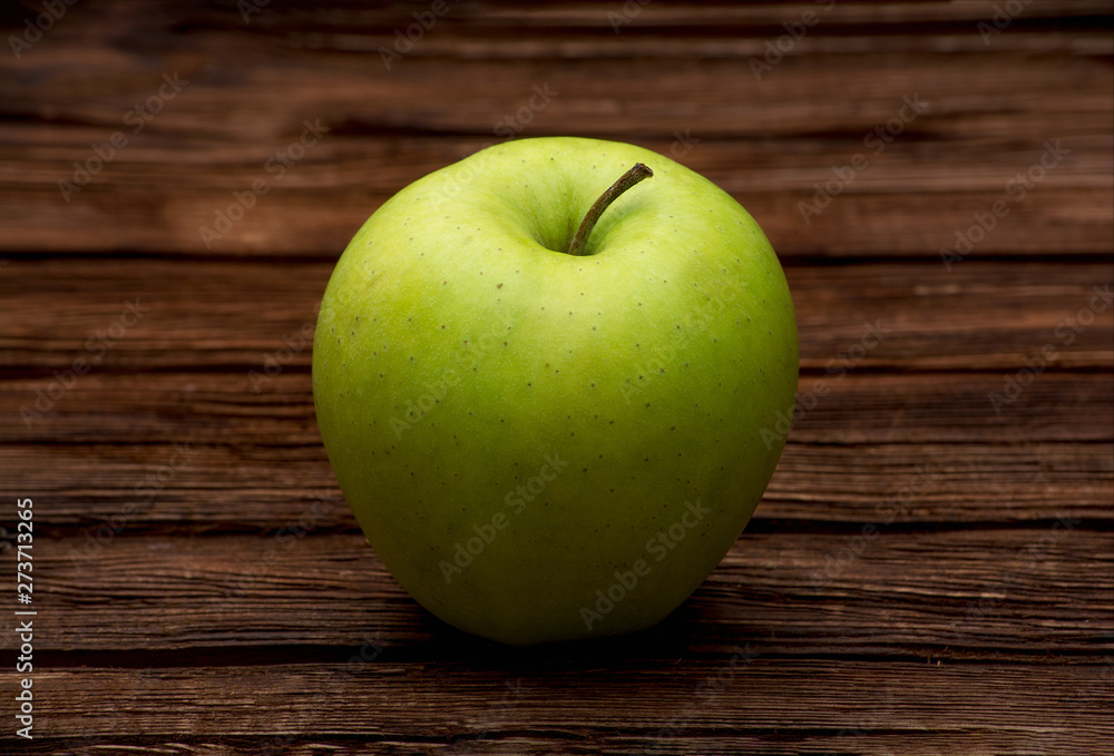 Green apple on dark brown wooden background. Summer fruits. Natural vitamins. Healthy food. Green apple on dark brown wooden background. Summer fruits. Natural vitamins. Healthy food.