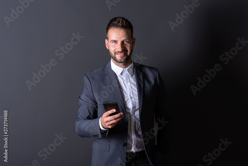 A smiling businessman using his smartphone