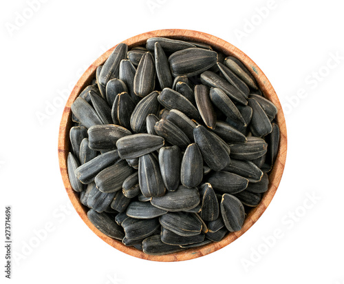 Roasted sunflower seeds in wooden plate on a white. The view of the top.