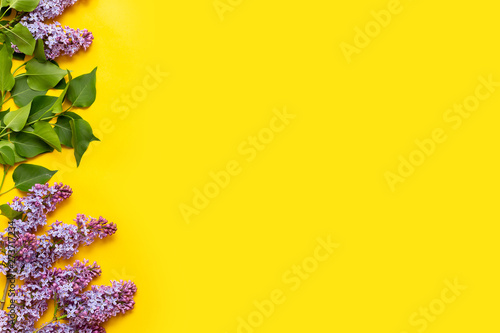 Decorative frame of lilac flowers and space for text. yellow background