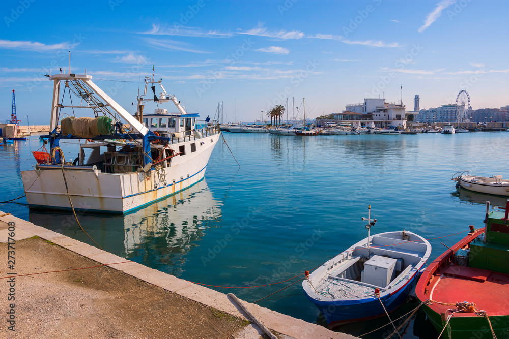 Beautiful landscape with fishing boats moored in the old harbor of Bari on the Adriatic sea coast, Puglia region, Southern Italy. 