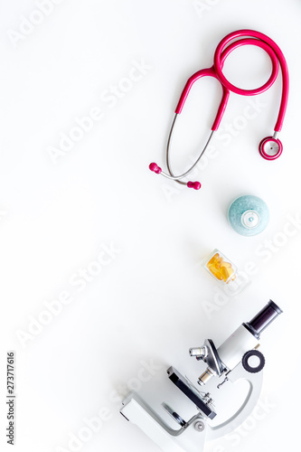 Do medical research with microscope, stethoscope, test-tubes in lab on white background top view mock-up