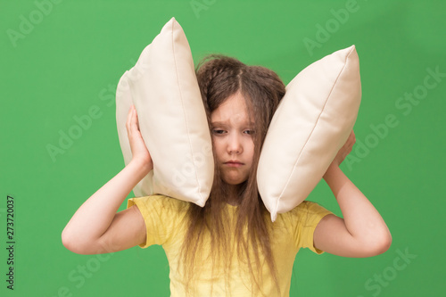 child covers the ears with pillows, the girl suffers from insomnia