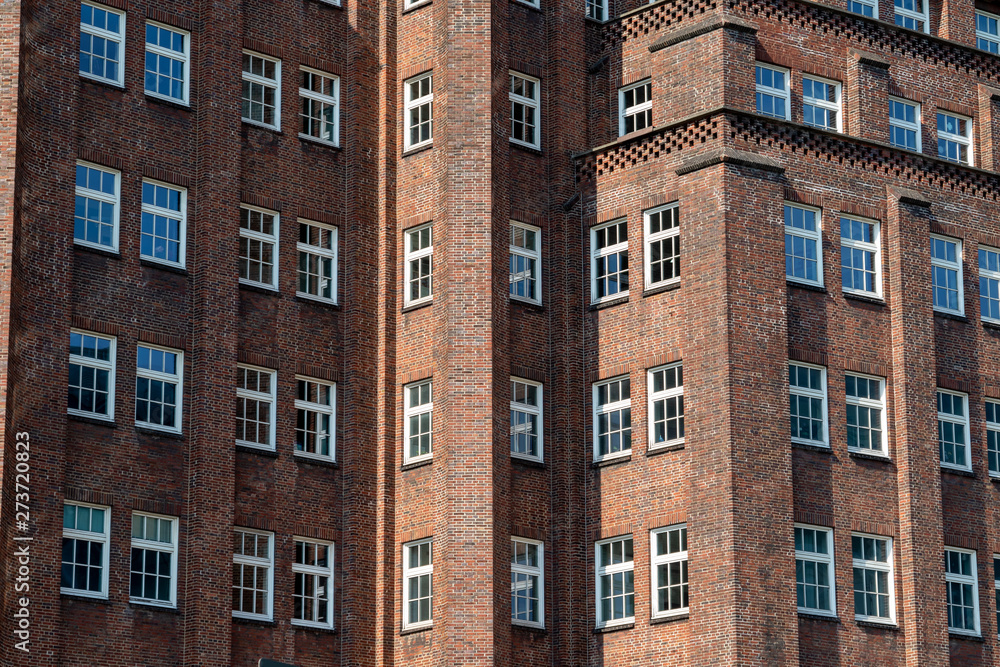 Fototapeta premium Lots of windows on the front of an old house with red brickwalls in an inner city in germany in summer