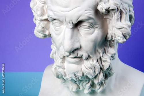Gypsum copy of ancient statue Homer head on a blue background. Plaster sculpture man face.