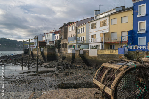 Fototapeta Naklejka Na Ścianę i Meble -  pueblo pesquero visto desde embarcadero con redes y nasas en primer plano