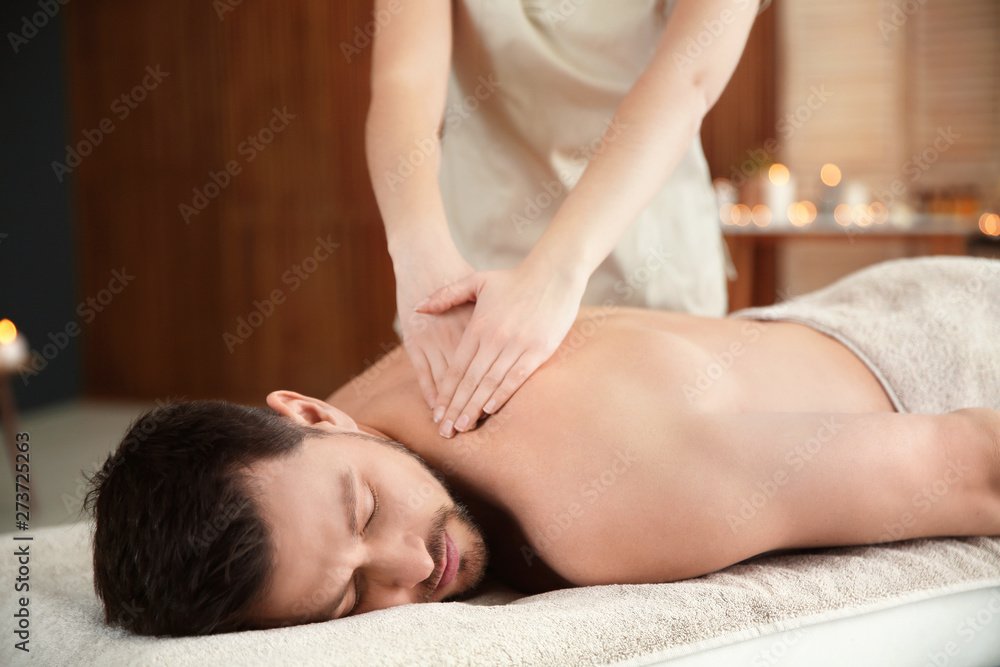Handsome man receiving back massage in spa salon Handsome man receiving back massage in spa salon