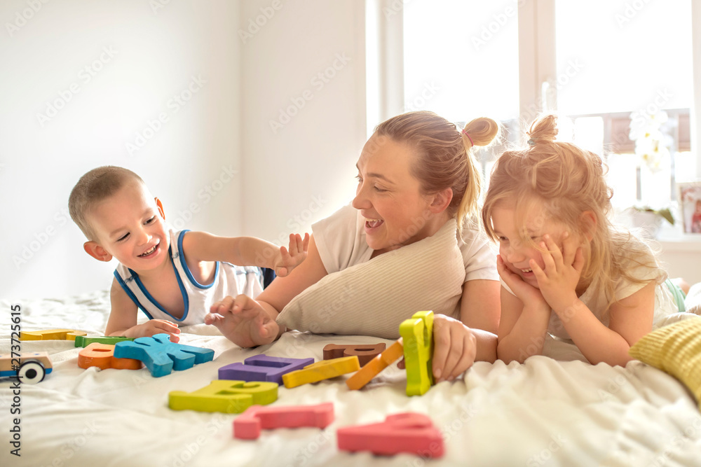Mother having fun with kids while learning them letters at home Mother having fun with kids while learning them letters at home