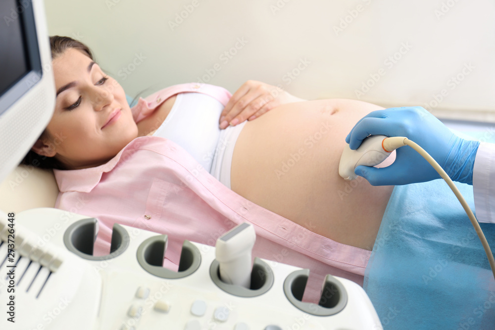 Obraz premium Young pregnant woman undergoing ultrasound scan in clinic