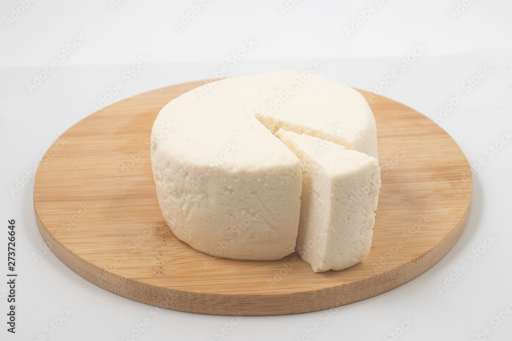 Slice of Ricotta Cheese over a wooden board