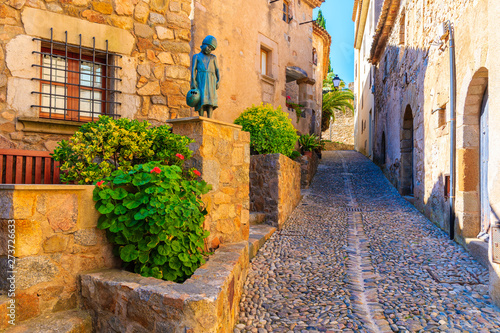 Narrow street with stone houses in old town in Tossa de Mar, Costa Brava, Spain
