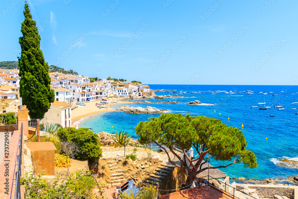 Amazing view of Calella de Palafrugell, scenic fishing village with white houses and sandy beach with clear blue water, Costa Brava, Catalonia, Spain