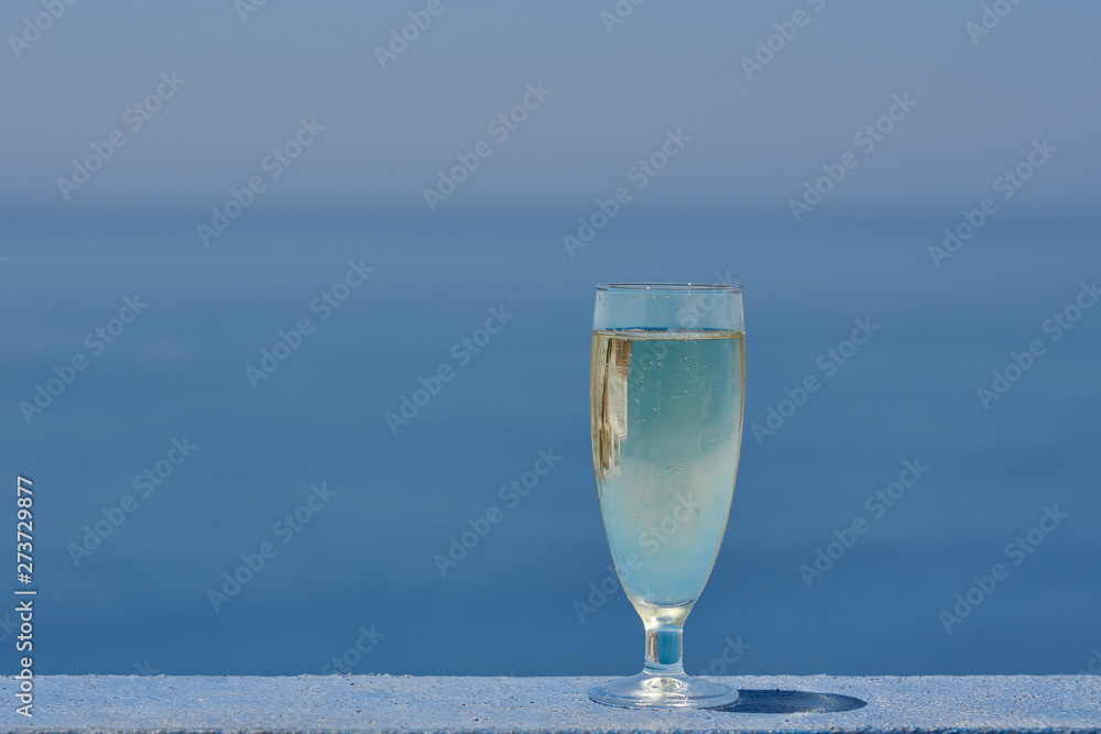 The glass of wine against the picturesque sea view illustrating the holiday and relax atmosphere. The glass of wine against the picturesque sea view illustrating the holiday and relax atmosphere.