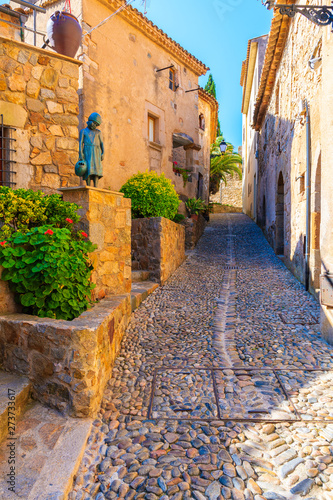 Narrow street with stone houses in old town in Tossa de Mar, Costa Brava, Spain