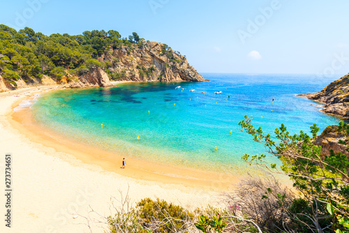 Young woman standing on Cala Giverola, most beautiful beach on Costa Brava, Spain