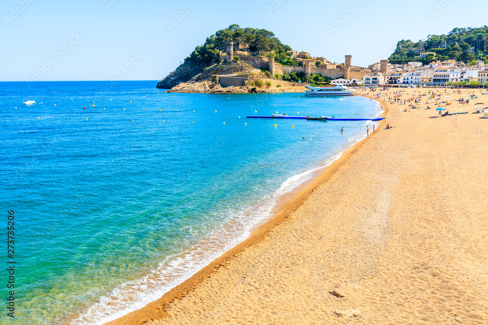 Azure blue water on idyllic beach in Tossa de Mar town, Costa Brava, Spain