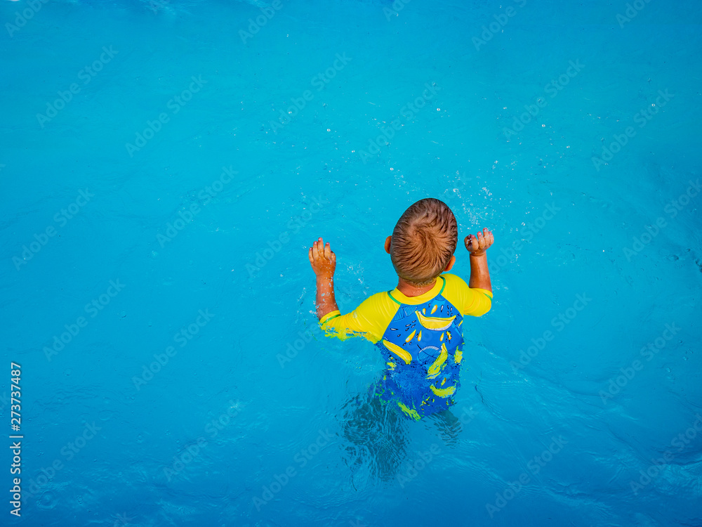 Little blonde boy  in hot summer day swim in carcas pool  in swimwear for boys.