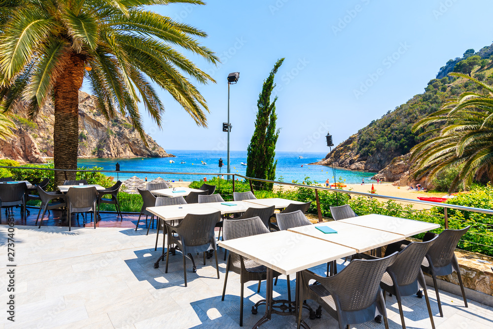 Restaurant tables in Cala Giverola, most beautiful beach on Costa Brava, Spain
