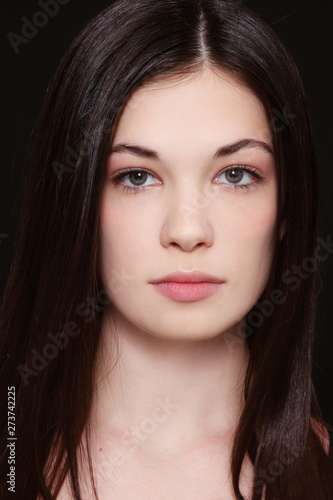 Young beautiful girl with dark long hair and clean makeup