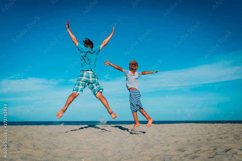 father and son have fun jump at tropical beach