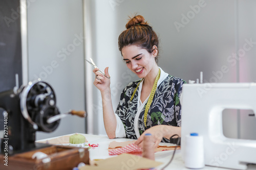 Teenage girl student practicing sewing on modern machine in cozy workshop photo