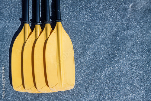 Yellow paddle blades on the gray textured background photo