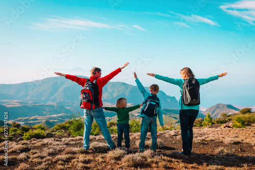 happy mom and dad with kids travel in mountains