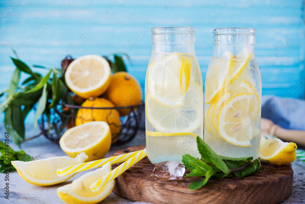 Cold refreshing drink with lemon and mint. Delicious summer lemonade with ice in the bottles. Cold refreshing drink with lemon and mint. Delicious summer lemonade with ice in the bottles.
