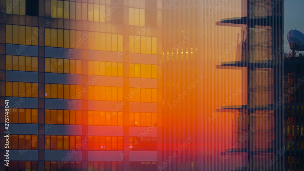 CLOSE UP: Blurry shot of a modern glassy skyscraper illuminated by the sunset. CLOSE UP: Blurry shot of a modern glassy skyscraper illuminated by the sunset.