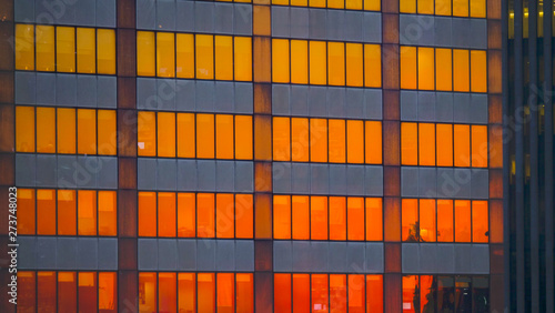 CLOSE UP: Burnt orange morning sky reflects off the windows of skyscrapers.