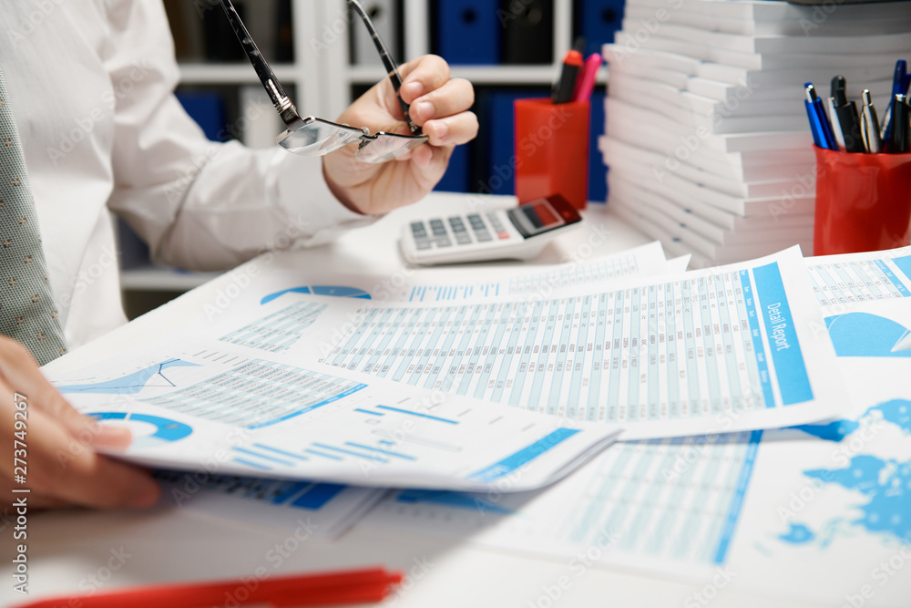 Businessman working and calculating, reads and writes reports. Office employee, table closeup. Business financial accounting concept. Businessman working and calculating, reads and writes reports. Office employee, table closeup. Business financial accounting concept.