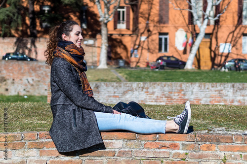 Ragazza seduta sull'erba è felice e si gode una giornata soleggiata photo