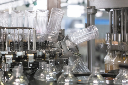 Bilde på lerret Plastic bottles inside industrial machine conveyor line or belt preparing for filling with drink